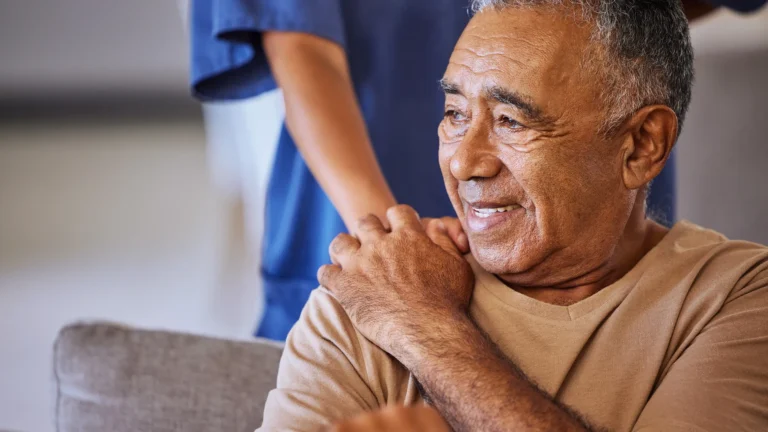 Elderly patient receiving supportive care from a medical professional.