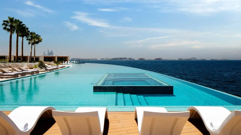 Infinity pool with a scenic view of Dubai skyline at a luxury Jumeirah resort.